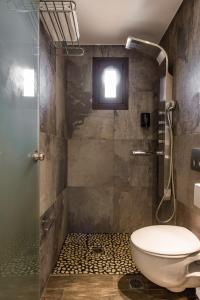 a bathroom with a shower and a toilet at GARDELLI RESORT in Laganas