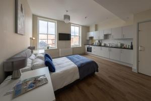 a bedroom with a large bed and a kitchen at Hereford City Centre - Apartment 7, Isabella House - Modern Apartment In The Heart of The City - Sleeps 2 Guests - Hosted by RENTMYHOUSE in Hereford