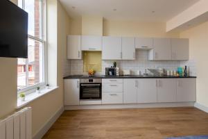 an empty kitchen with white cabinets and a window at Hereford City Centre - Apartment 7, Isabella House - Modern Apartment In The Heart of The City - Sleeps 2 Guests - Hosted by RENTMYHOUSE in Hereford +3 photos