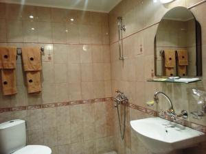 a bathroom with a sink and a toilet and a mirror at Family Hotel Silvestar in Veliko Tŭrnovo