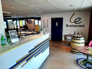 a restaurant with a counter and a table and chairs at Kyriad Blois Nord in Blois