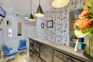 una habitación con 2 sillas azules y un mostrador con un jarrón en Hotel Riviera Elysees, en París 35 fotos más