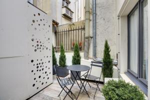 un pequeño patio con mesa y sillas en el balcón en Hotel Riviera Elysees, en París