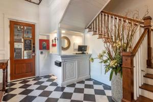 a hallway with a checkered floor and a staircase at Inn at I'On, Ascend Hotel Collection in Charleston