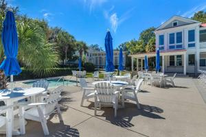 een groep tafels en stoelen met blauwe parasols bij Inn at I'On, Ascend Hotel Collection in Charleston