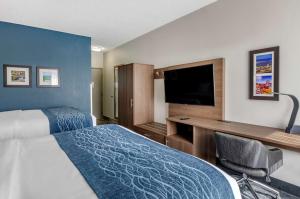 a hotel room with a bed and a flat screen tv at Comfort Inn & Suites Troutville - Roanoke North - Daleville in Troutville