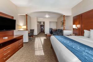 レッドランズにあるCitrus Suites Redlands Loma Linda Hotelのベッドと薄型テレビがあるホテルの部屋