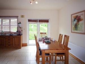 a dining room with a wooden table and chairs at Cois Chnoic Holiday Home Dingle in Dingle