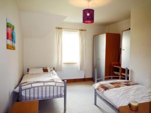 1 dormitorio con 2 camas y ventana en Cois Chnoic Holiday Home Dingle en Dingle