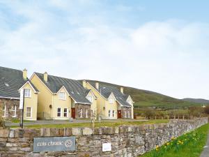 una fila de casas detrás de una pared de piedra en Cois Chnoic Holiday Home Dingle, en Dingle