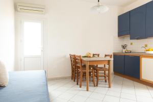 a kitchen with blue cabinets and a table and chairs at Sea View Home -Bilocale Angolo Cottura Vista Mare 4 pax in Albinia