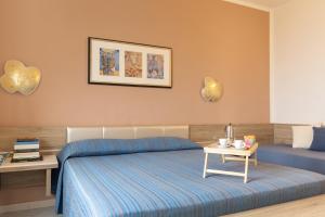 a bedroom with a blue bed and a table at Sea View Home -Bilocale Angolo Cottura Vista Mare 4 pax in Albinia
