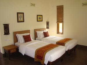 una habitación de hotel con 2 camas en una habitación en Musa Jungle Retreat, en Kumguri