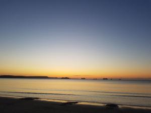 una puesta de sol en una playa con el océano en Seaspray Guest House en Weymouth