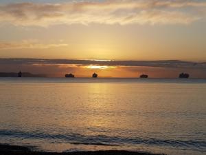 una puesta de sol sobre el océano con barcos en el agua en Seaspray Guest House en Weymouth