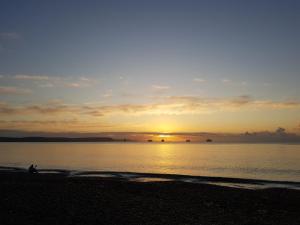 a person walking on the beach at sunset at Seaspray Guest House in Weymouth