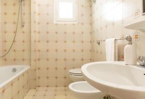 uma casa de banho com um WC branco e um lavatório. em Sweet Home Isolotto - direttamente sulla spiaggia em Albinia