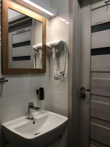 ein Bad mit einem Waschbecken und einem Spiegel in der Unterkunft Zamkowy Apartament in Lublin