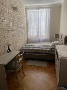 1 dormitorio con cama, escritorio y ventana en Zamkowy Apartament en Lublin