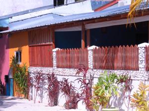 a house with a fence and plants in front of it at The Sunrise Huraa in Huraa