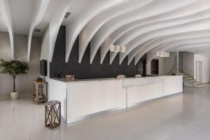 a lobby with a white counter and a ceiling at GARDELLI RESORT in Laganas