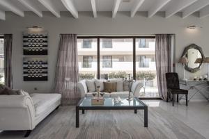 a living room with a white couch and a table at GARDELLI RESORT in Laganas