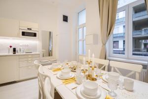 a white dining room with a white table and chairs at BpR LYNX Home with A/C in Budapest