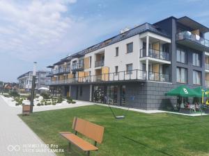 un edificio con una panchina davanti di APARTAMENT BLUE , Marynarska 8 , Sarbinowo a Sarbinowo