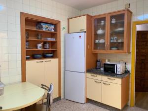 a kitchen with a white refrigerator and a table at Armada in Tui