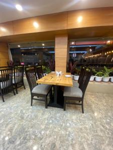 a dining room with a wooden table and chairs at Hotel Aditya Residency in Bhopal +38 photos
