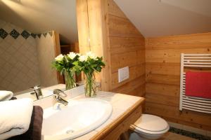 uma casa de banho com um lavatório e um vaso de flores em Cordée Côté Sud em Morzine