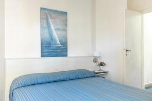 um quarto com uma cama com um quadro na parede em Isola Rossa · Villetta Isola Rossa con spiaggia&piscina em Albinia