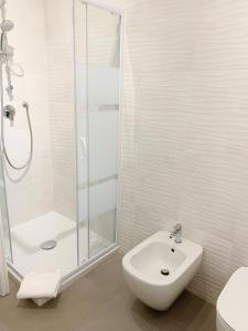 bagno bianco con doccia e lavandino di Alghero CHARMING APARTMENTS DOWNTOWN ad Alghero