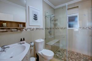 a bathroom with a toilet and a sink and a shower at Oppiesee Selfcatering Apartments in Herolds Bay