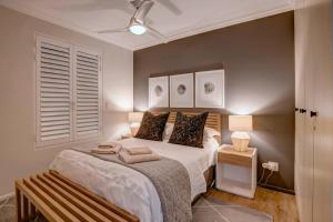 a bedroom with a large bed and a window at Oppiesee Selfcatering Apartments in Herolds Bay