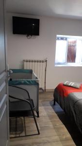 a bedroom with a bed and a tv on the wall at Les TREMIERES in Saint-Paul-des-Fonts