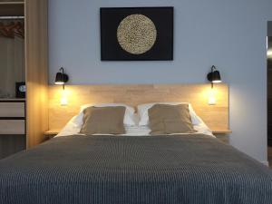 a bedroom with a large bed with two lights on it at nuit sur le pont 3 in Landerneau