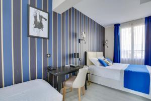 Una habitación de hotel con dos camas y un escritorio. en Hotel Riviera Elysees, en París