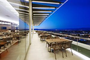 un restaurante con mesas y sillas y vistas a la ciudad en Crowne Plaza Bursa Convention Center & Thermal Spa, an IHG Hotel en Bursa