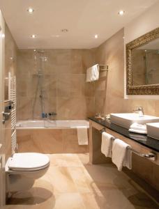 een badkamer met een toilet, een bad en een wastafel bij Hotel Royal Jülich in Jülich
