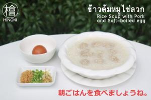 un tazón de sopa de arroz con cerdo y huevo pasado por agua. en Hinoki Hotel - ONSEN Chiang Mai en Chiang Mai