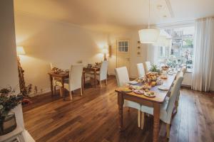 a dining room with a table and white chairs at B&B de Zandtaart in Egmond aan Zee