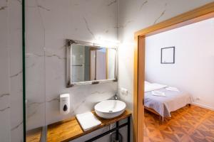 ein Badezimmer mit Waschbecken und Spiegel und einem Bett in der Unterkunft Kamienica Zamenhofa - Apartamenty na wynajem in Białystok + 177 Fotos