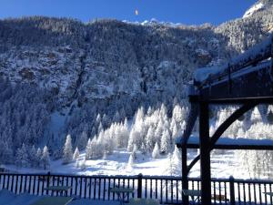a view of a snow covered mountain with trees at Hôtel Spa la Cascade in Ceillac