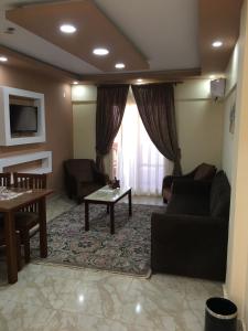 uma sala de estar com um sofá e uma mesa em Jewel El Gameel Hotel em Port Said