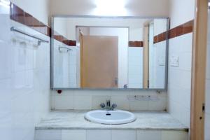 a bathroom with a sink and a mirror at DAFFODILS SERVICED APARTMENT in Chennai