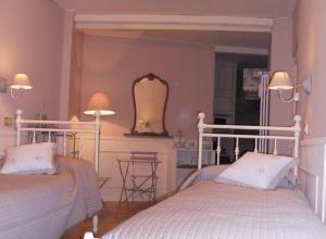 sypialnia z 2 łóżkami i lustrem w obiekcie Bed & Breakfast Sant'Erasmo w Bergamo
