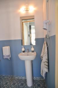La salle de bains est pourvue d'un lavabo et d'un miroir. dans l'établissement Habit, à Ermoúpoli