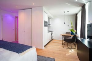 a bedroom with a bed and a desk and a kitchen at MUNICH FINEST APARTMENTS in Munich