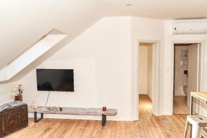 a living room with a bench and a tv on a wall at Apartmán NEWSTALGIE in Mikulov